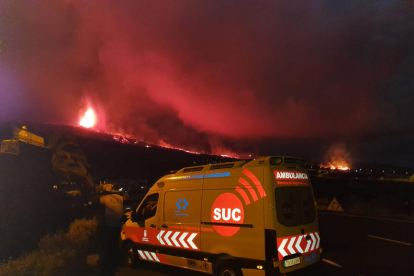 Una ambulancia con el volcán en erupción en la Palma.