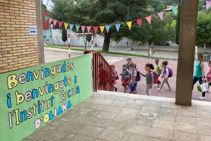 El momento de la entrada en el Institut Escola de Oliana (Alt Urgell) de un grupo de alumnos en el primer día de curso escolar, donde se ve un cartel que les da la bienvenida en el nuevo instituto escuela.
