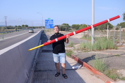 Pla obert de l'activista per l'alliberament de l'AP-7, Llorenç Navarro, amb una de les barreres a l'antic peatge de l'Aldea.