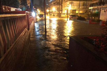 Pla mitjà d'un dels carrers del barri de la Salut de Salou, ple d'aigua després del desbordament del barranc de Barenys.