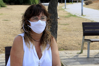 Sílvia Soler, portaveu del Col·lectiu d'afectades i afectats persistents per la covid-19, asseguda en un banc del Passeig Marítim de Castelldefels