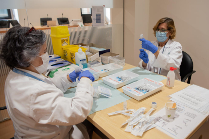 Dos profesionales preparan la tercera dosis de la vacuna para personal del Hospital Clínic.