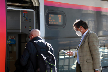 Dos passatgers pugen al tren a l'estació de Perpinyà.
