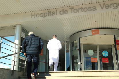 Un facultatiu i un pacient entrant a l'Hospital Verge de la Cinta de Tortosa.