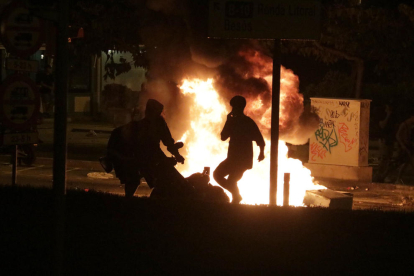 Dos jóvenes queman una moto durante los disturbios posteriores al botellón del Bogatell.