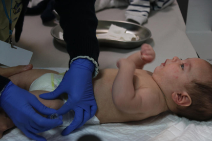 Una pediatra del CAP del barri del Clot administra la vacuna del meningococ a un nen de dos mesos.