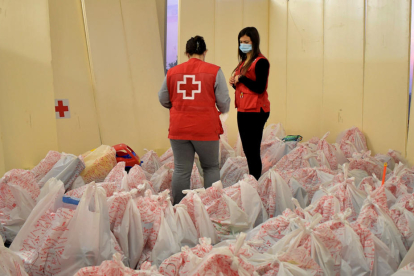 Pla general de dues voluntàries revisant les bosses de la Campanya de Joguines de la Creu Roja a Tarragona i l'Ebre.