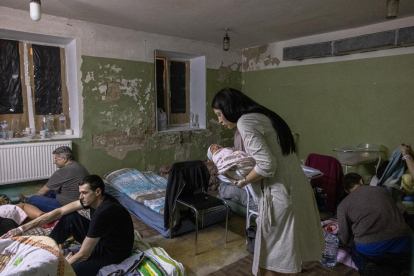Una mare agafa en braços al seu fill nounat al soterrani d'un hospital de maternitat, utilitzat ara com a refugi antiaeri a Kíev.