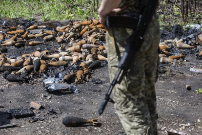 Un soldat ucraïnès observa desenes de mines desarmades després que l'exèrcit rus deixés la població de Mala Rohan.