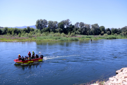 Una embarcación de los bomberos buscando el cuerpo del joven desaparecido al río Ebro, en Benissanet.