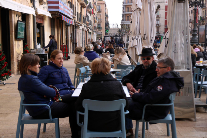 Pla general d'un grup de dones consumint en una de les terrasses dels restaurants de la plaça de la Font de Tarragona.