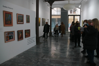 Una visitant fotografia l'exposició 'Gabriel Ferrater, pintor. Diàlegs inèdits'.