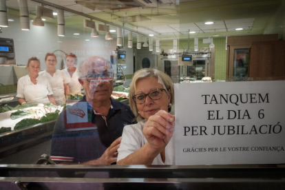 Jordi Martí Just i Maria Teresa Adell posen el cartell de «Tancats per jubilació».