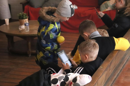 Varios niños refugiados jugando en la sala de estar de una casa de colonias.