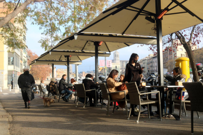 Clientes desayunando en una terraza de la plaza Catalunya de Gerona.