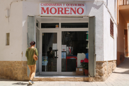 Una vecina entra en la única tienda de comestibles de Caseres.