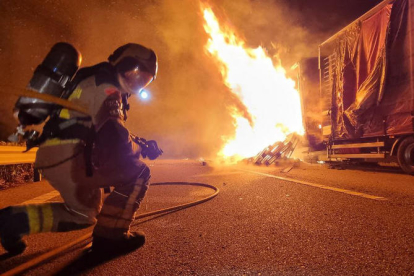 Un bombero extinguiendo el fuego del camión.