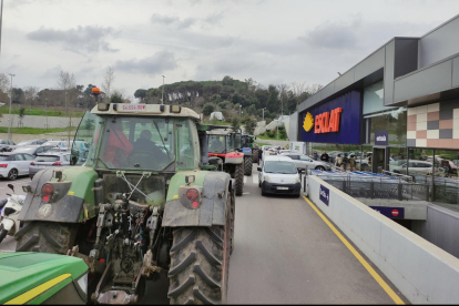 Una cua de tractors entrant a l'aparcament d'un supermercat de Girona.