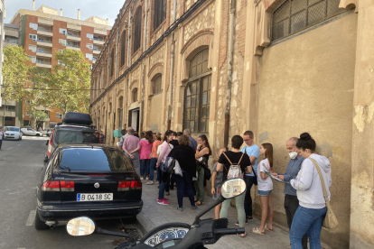 Alguns dels visitants de la fàbrica Baget esperant per entrar a l'edifici, ahir.