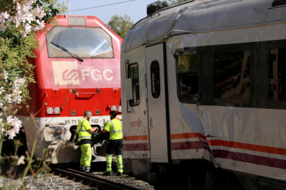 Operarios de Adif y de Renfe haciendo tareas para retirar la locomotora accidentada en el choque con un tren regional en Vila-seca.