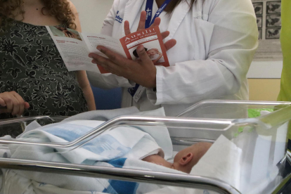 Una enfermera de Vall d'Hebron explica a unos padres los riesgos de sacudir un bebé.