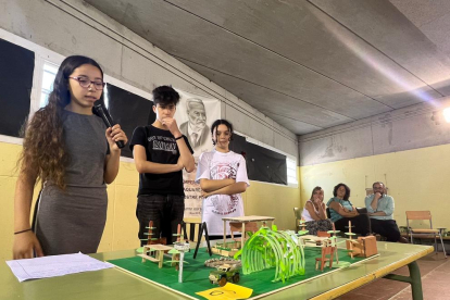 Tres alumnes durant la presentació del refugi climàtic.