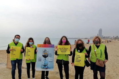 Activistas de Greenpeace en la playa de Mar Bella de Barcelona para alertar sobre el estado de los océanos.