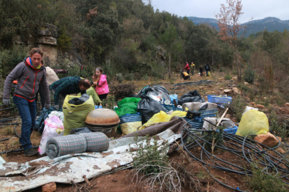 Voluntaris recollint les restes d'un campament d'una plantació de marihuana a Mont-ral.