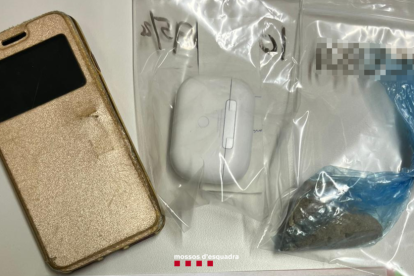 Imatge del telèfon mòbil robat, l'heroïna i els auriculars que l'individu portava abans de ser detingut.