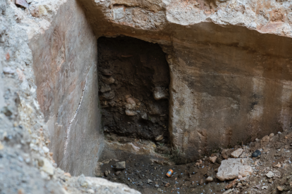 Detall de la porta d'entrada a la cisterna, coberta de sediments.