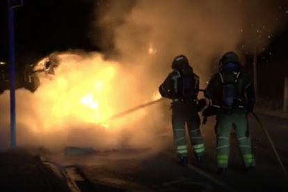 Dos bombers durant es tasques d'extinció d'un incendi durant la revetlla.