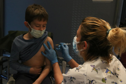 Un niño poniéndose la vaccinia contra la covid-19 en Girona.