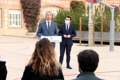 El conseller d'Educació, Josep Gonzàlez-Cambray, en roda de premsa, al president de la Generalitat, Pere Aragonès, escoltant-lo.