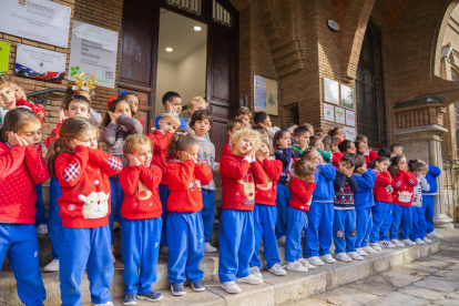 Los alumnos cantan en las escaleras de la puerta de la escuela.