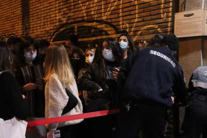 Un guàrdia de seguretat de la sala Razzmatazz obrint la tanca de la discoteca a les 00.30h en la primera nit de reobertura.