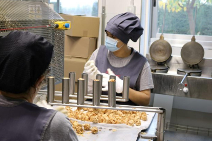 Dos trabajadoras de El Rosal de Tàrrega elaborando galletas.