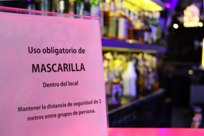 Detalle de un cartel en un bar musical indicando a los clientes el uso obligatorio de mascarilla dentro del establecimiento.