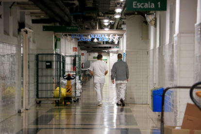 Dos sanitaris caminant per un dels passadissos de l'Hospital Clínic de Barcelona.