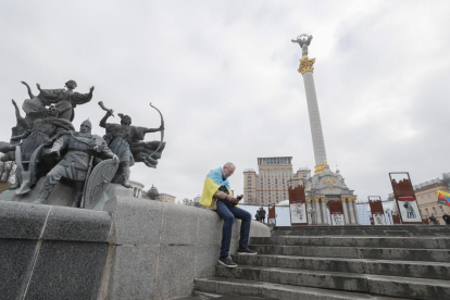 Un hombre con la bandera de Ucrania en la plaza de la Independencia de Kiev.