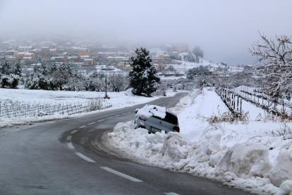 Paisaje nevado en Horta de Sant Joan con un vehículo que ha salido de la vía a la entrada al pueblo.