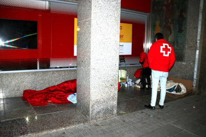 Voluntaris de la Creu Roja oferint mantes i begudes als sensesostres durant l'Operació Iglú.