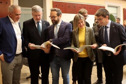 El conseller, l'alcalde de Tarragona, l'alcaldessa accidental de Reus, el delegat del Govern a Tarragona i el rector de la URV mirant el llibre.