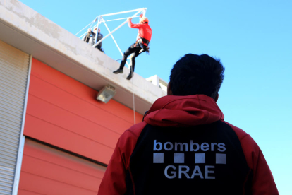Un agent dels GRAE mirant una pràctica de rescat de dos companys de la unitat a Valls.