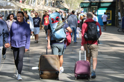 Turistes amb maletes per la Rambla a Barcelona.