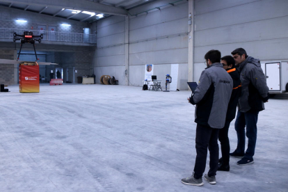Responsables y técnicos de Ebredrone envuelven un dron dentro de la nave del CoEbreLab del polígono de Molló de Móra la Nova durante la I Muestra de proyectos.