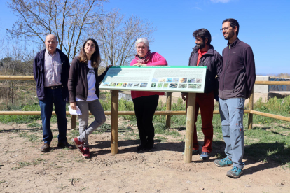 Les regidores de Medi Ambient i Districtes de Tarragona, Eva Minguell i Paula Varas, així com l'equip de l'Associació Aurora al costat d'un cartell informatiu sobre la biodiversitat rescolsa de Sant Salvador.