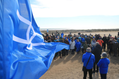 Una banderola de la Plataforma en Defensa del Ebro ondea durante la concentración en la playa del Trabucador.