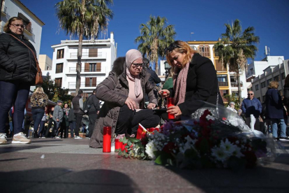Dos mujeres colocan una vela en el lugar donde asesinaron al sacristán de Algeciras.