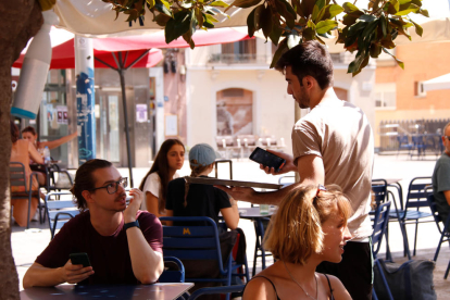 Un cambrer a la terrassa del bar Sol Soler de Gràcia.