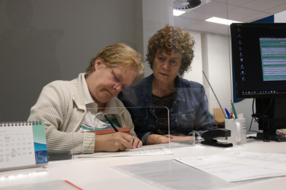 Dues usuàries fent un tràmit a l'oficina de l'Agència Tributària de Catalunya a Figueres.